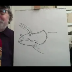A man and woman standing on either side of an easel with a drawing of a triceratops head on it.