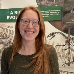 Woman with red hair wearing glasses and green sweater
