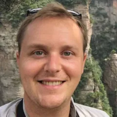 A portrait of Morgan Gostel with cliffs in the background. 