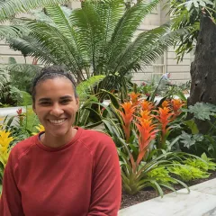 woman in red sweater sitting in front of garden