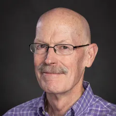 Image of man with glasses wearing a plaid shirt