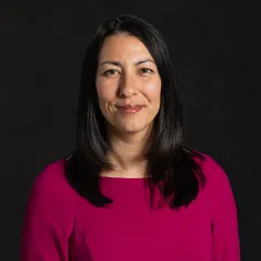 A headshot of Virginia Kromm with a black background. 