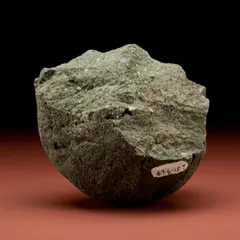 Grayish-brown stone with a curved bottom and jagged top.