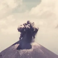 Image of large plume of dark ash emerging from the top of a volcano.