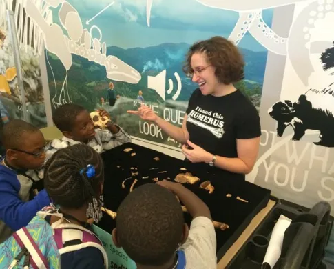 Briana explaining some fossils to school children