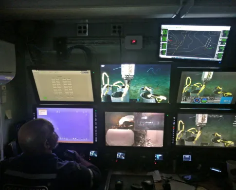 A man looking at many computer monitors