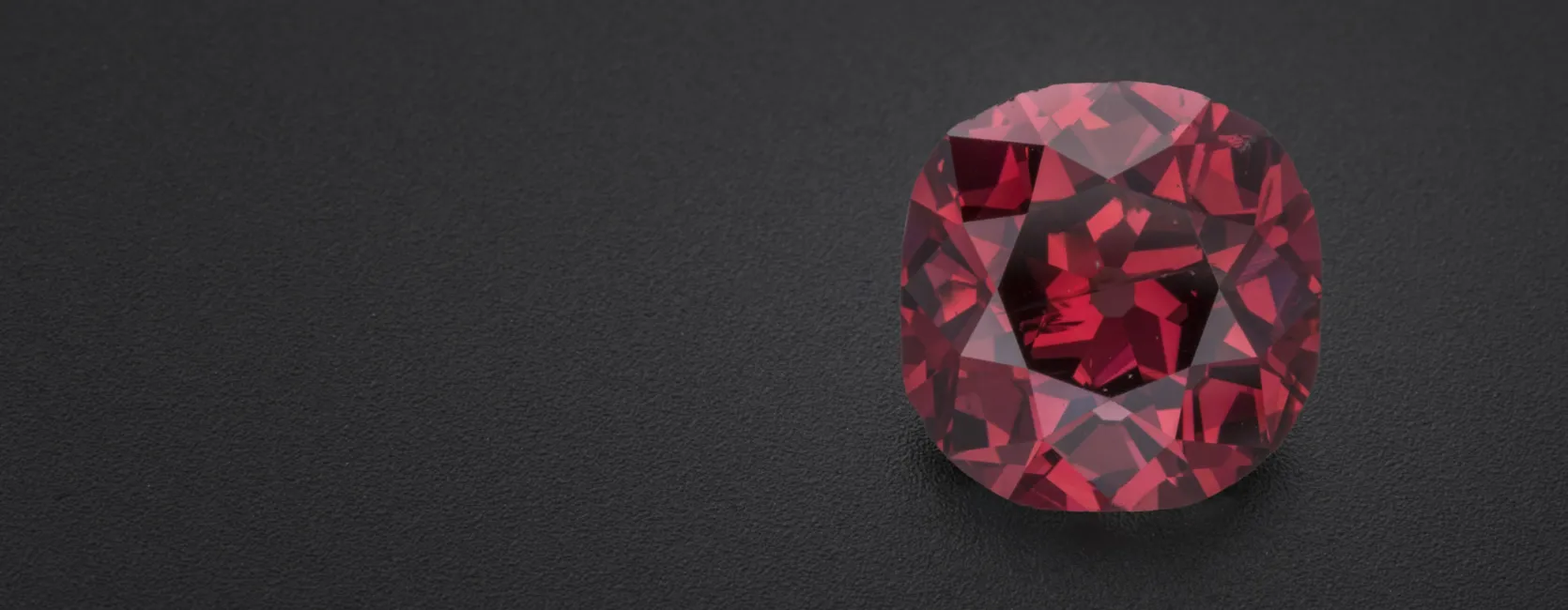 Red diamond gem offset to the right on a black background