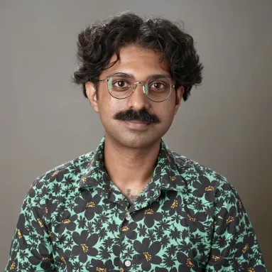 Man with mustache wearing glasses and green floral shirt