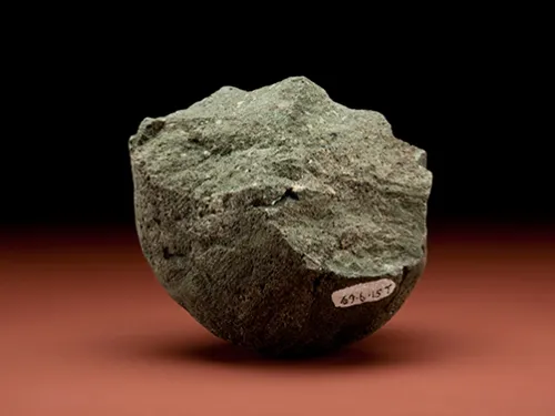Grayish-brown stone with a curved bottom and jagged top.