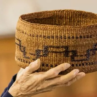 Pair of hands holding round basket