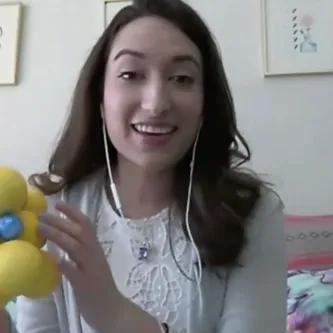 Geologist Gabriela Farfan holding a ball and stick model of a mineral molecule.