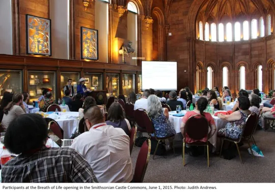Participants for the opening of Breath of Life sitting at tables in the Smithsonian Castle commons.