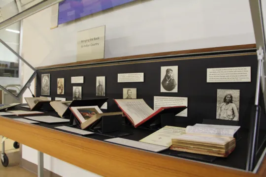 Open books displayed in front of portraits.