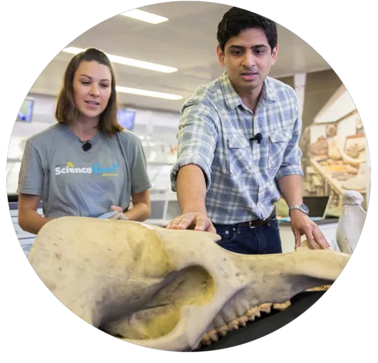 A Smithsonian educator and scientist observe a fossil. 