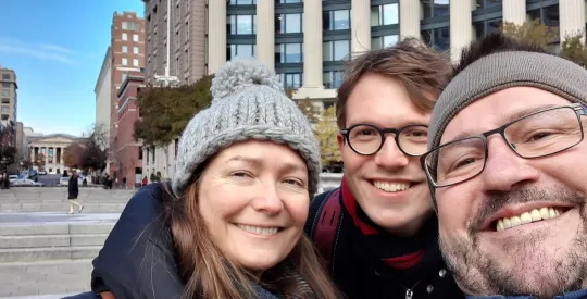 Three people dressed for winter smiling for the camera.