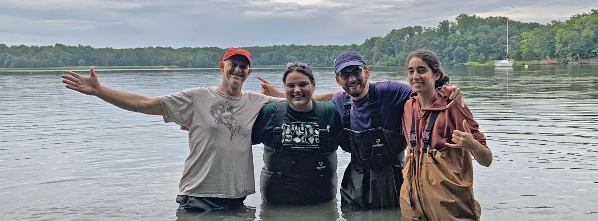 4 people posing in front of an ocean