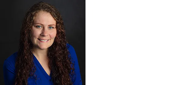 Portrait of Jessica Zehnpfennig, a light-skinned woman with long reddish-brown hair, who is wearing a blue button-down shirt.