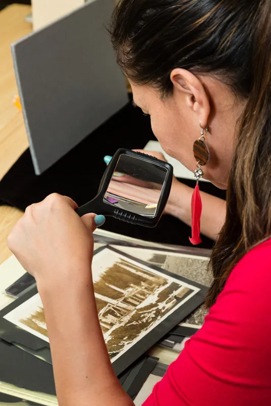 Researcher looking at historic photograph at the National Anthropological Archives